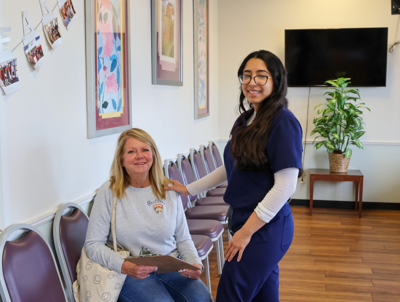 Volunter and a nurse joining hands in teamwork.